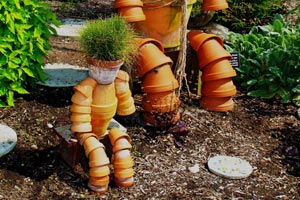 Un muñeco cuidador de jardín hecho con macetas